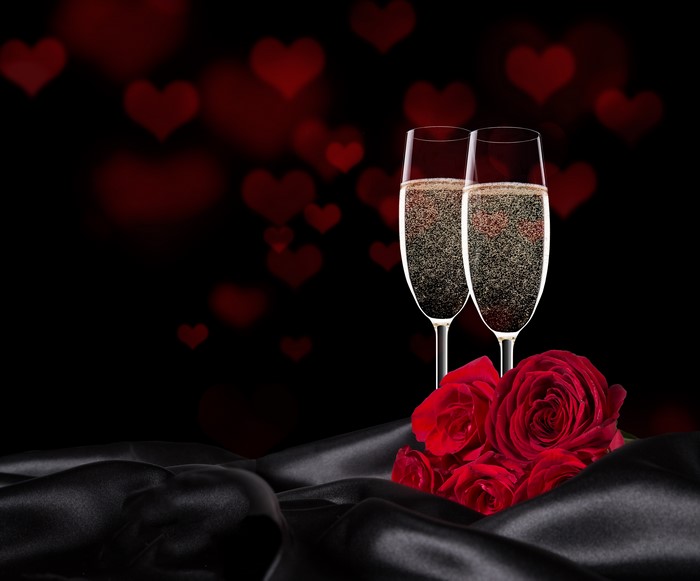 Champagne glasses with roses and heart bokeh