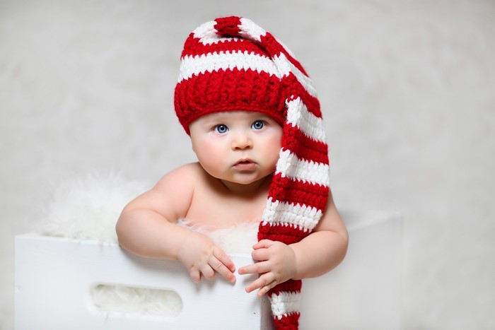 Baby wearing a red and white striped elf hat