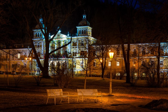 Building at night with street lights and benches in Usovice