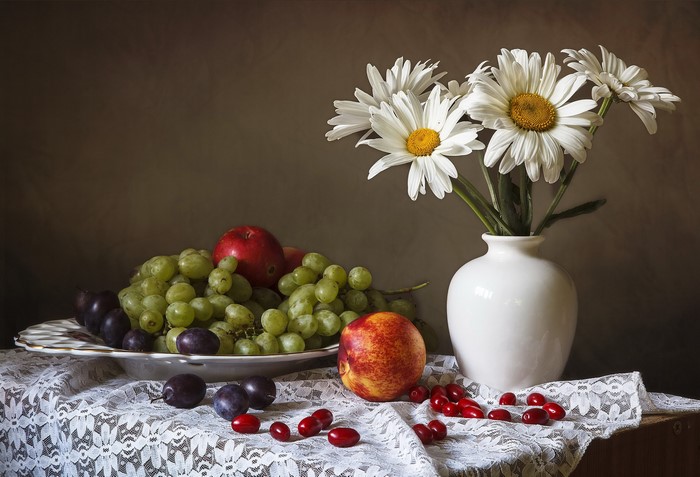 Still-life with fruits and daisies in a vase