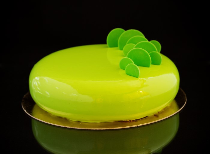 Lime green mirror glaze cake with green decorations