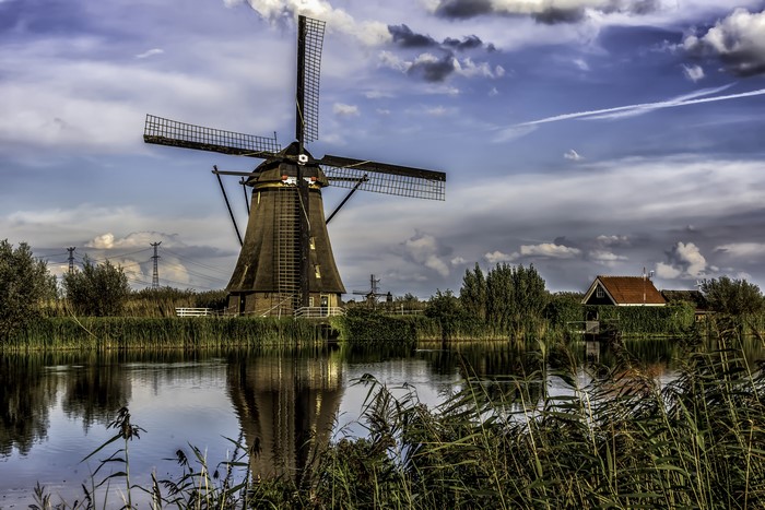 Windmill and house by the river in Kinderdijk, Netherlands
