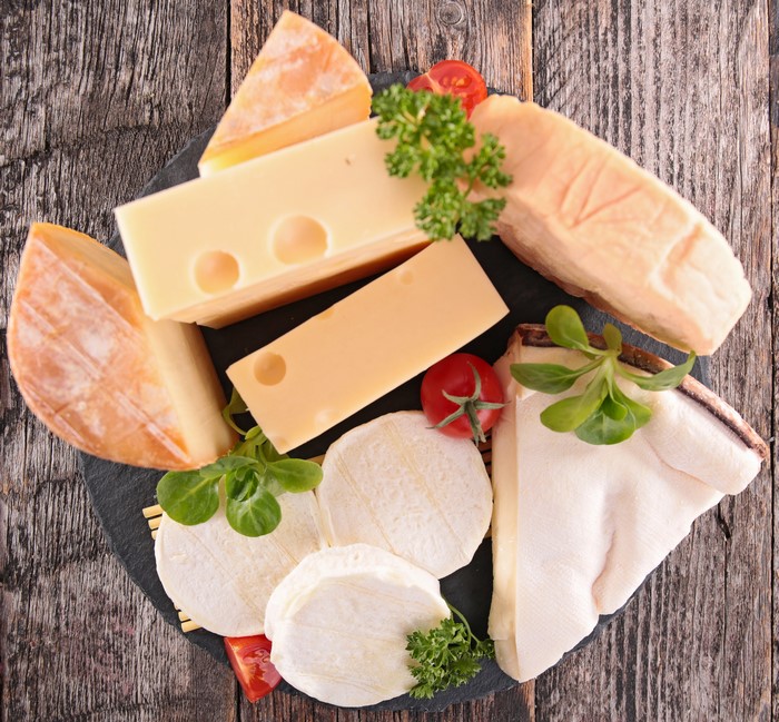 Assortment of cheeses on a wooden background