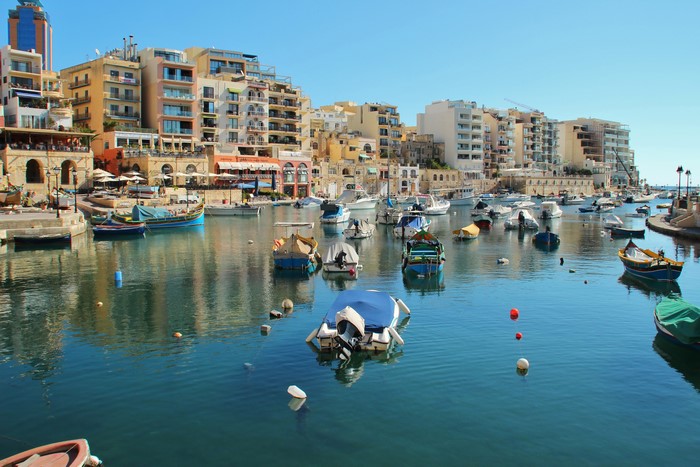 Boats docked in a bay with buildings in Saint Julian's, Malta