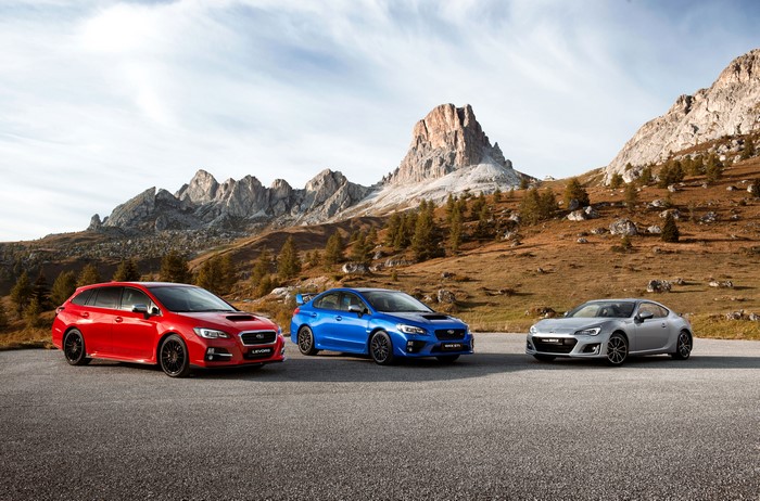 Three Subaru cars in a mountain landscape