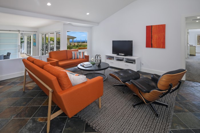 Living room with orange sofas and Eames chair