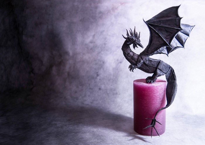 Origami dragon on a pink candle