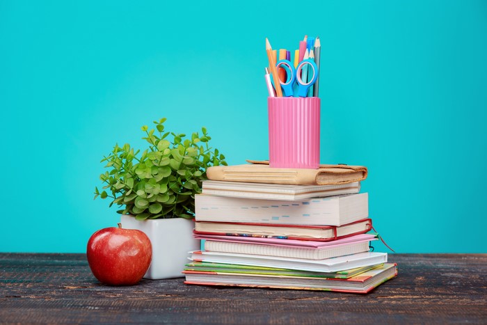 Stack of books with school supplies and apple