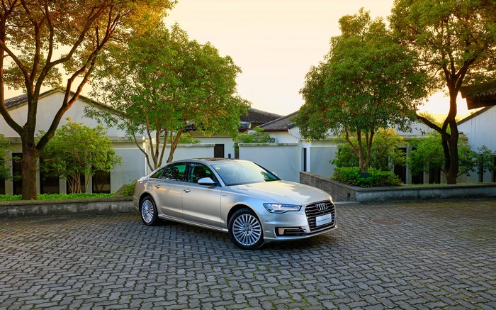 Silver Audi A6 L e-tron parked on cobblestone