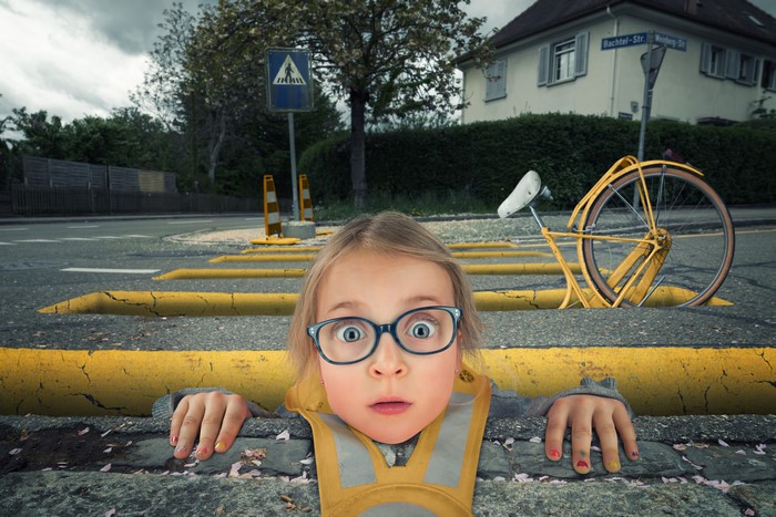 Girl with glasses on a street with a yellow bike