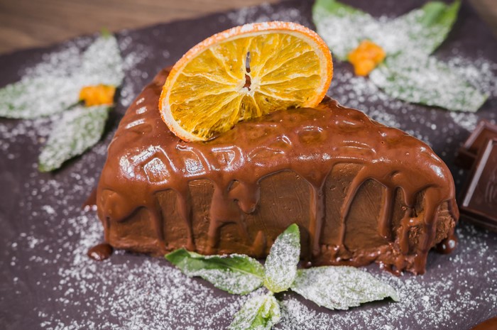 Chocolate cake with orange slice and mint
