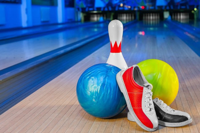 Bowling pin, balls, and shoes on lane