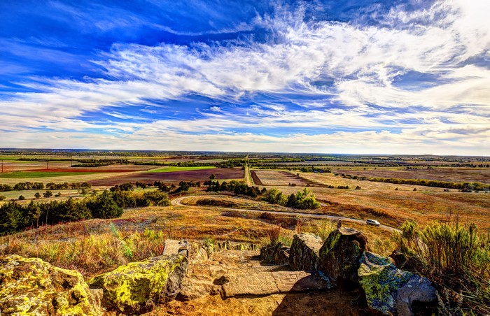 View from a rocky outcrop overlooking Kansas fields under a cloudy sky