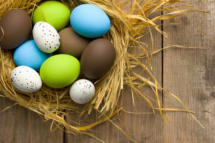 Easter eggs in a nest on wooden background