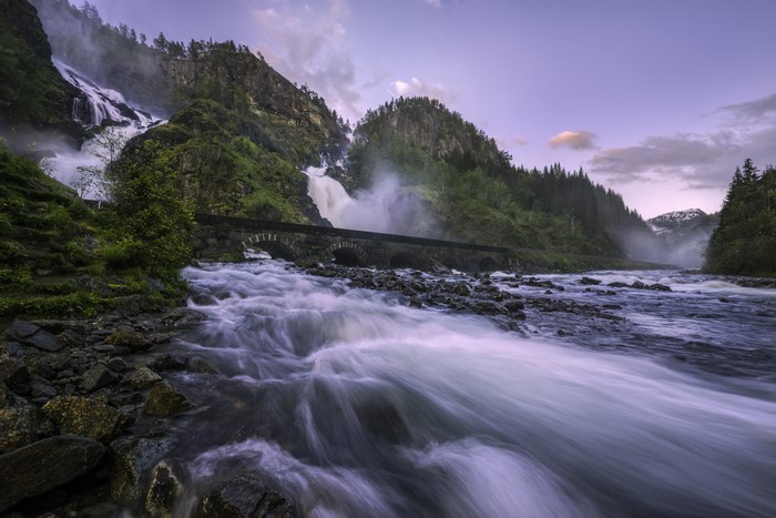 Latefossen waterfall and river with stone bridge in Norway