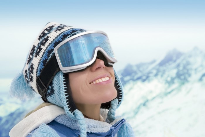 Woman wearing winter hat and goggles in mountains