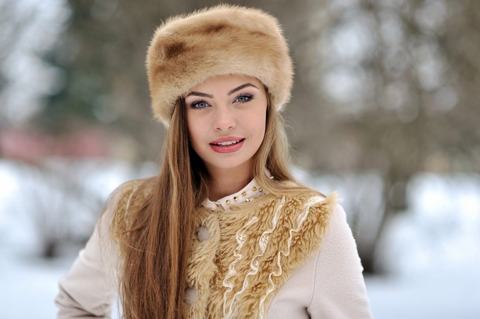 Woman with dark blonde hair wearing a fur hat