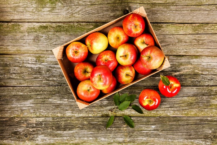 Apples in a wooden box on wood planks