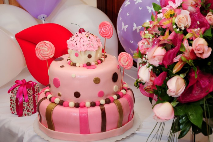 Pink Two-Tiered Cake with Cupcake Topper and Flowers