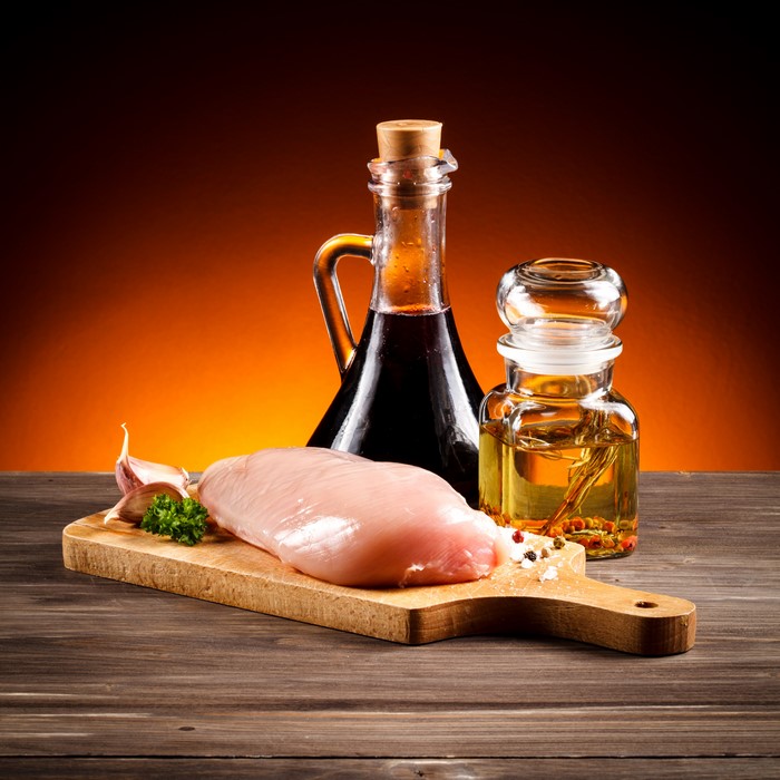 Raw chicken breast with garlic, oil, and vinegar