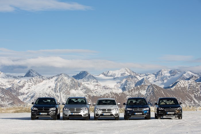 BMW cars in front of snowy mountains