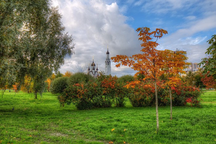 Autumn park with church and buildings in St. Petersburg, Russia