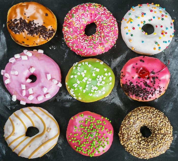 Nine assorted donuts on a dark background