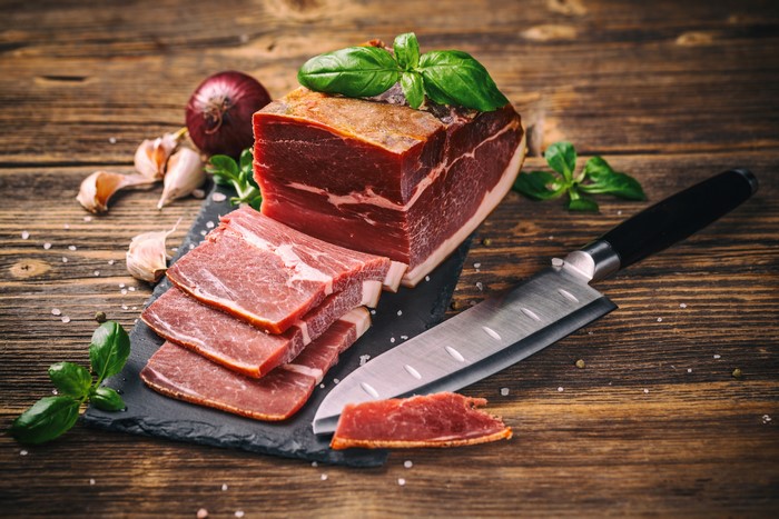 Ham with Onion, Garlic, and Knife on Wood