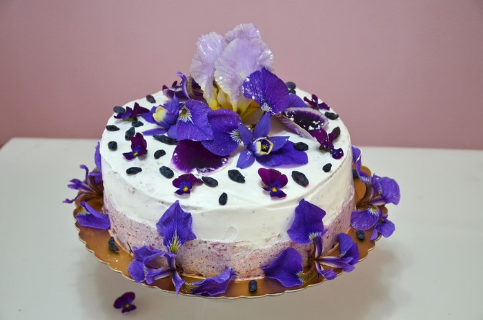 Cake decorated with purple irises and berries