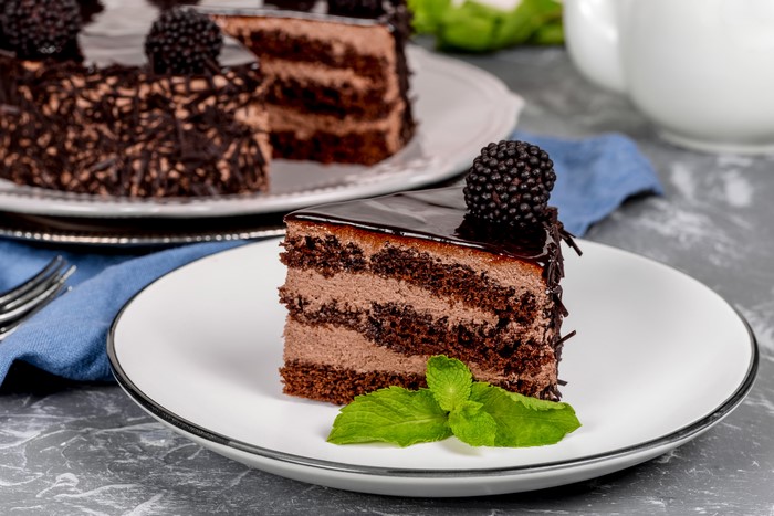 Chocolate cake slice with blackberry and mint
