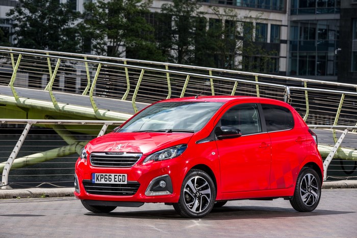 Red Peugeot 108 car on a bridge