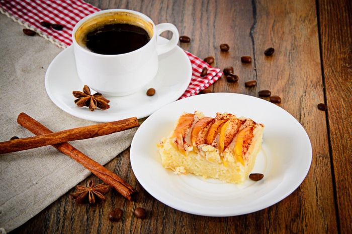 Coffee, pastry, cinnamon, and star anise on a wooden table