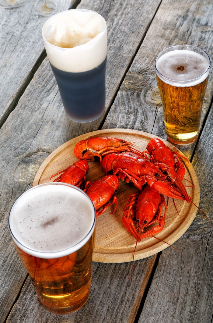 Three beers and crayfish on a wooden table