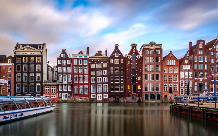 Amsterdam canal with houseboats and historic buildings