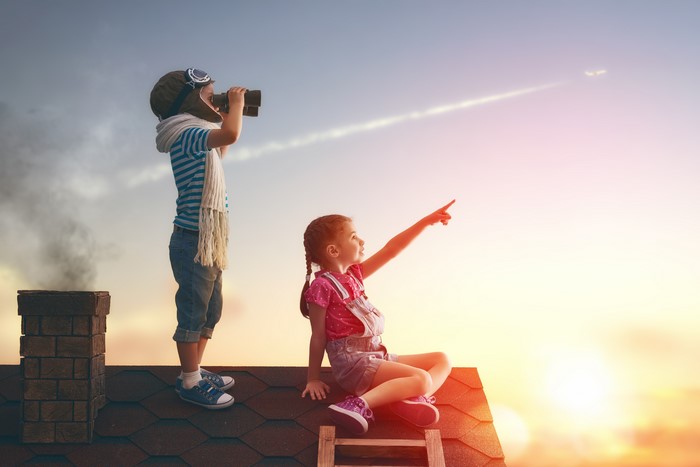 Children on a roof looking at a plane