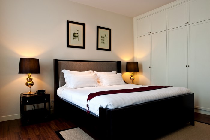 Bedroom with bed, lamps, and wardrobe