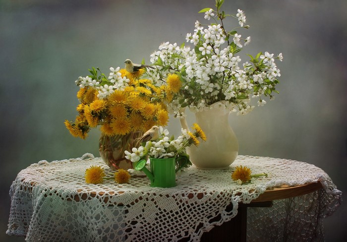 Still-life with dandelions and flowering trees in vases