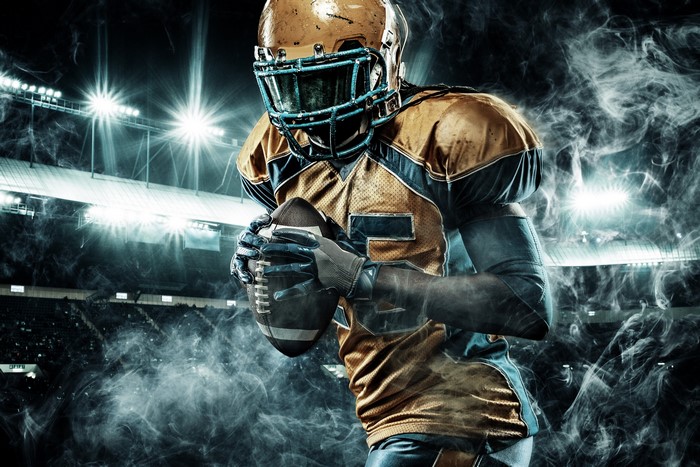 American football player in uniform holding a ball