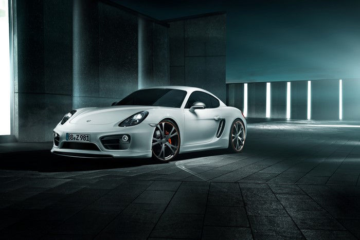 White TechArt Porsche Cayman parked in modern architecture