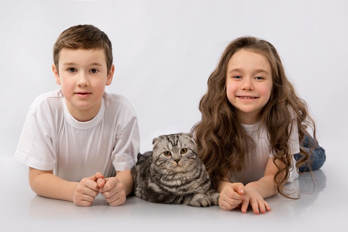 Boy, Girl, and Cat on Gray Background