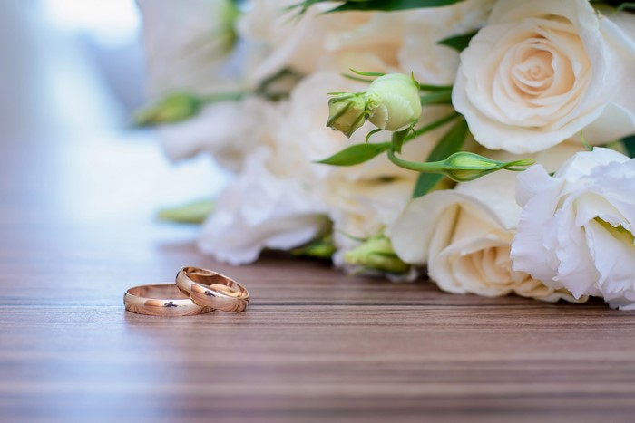 Wedding rings and white roses