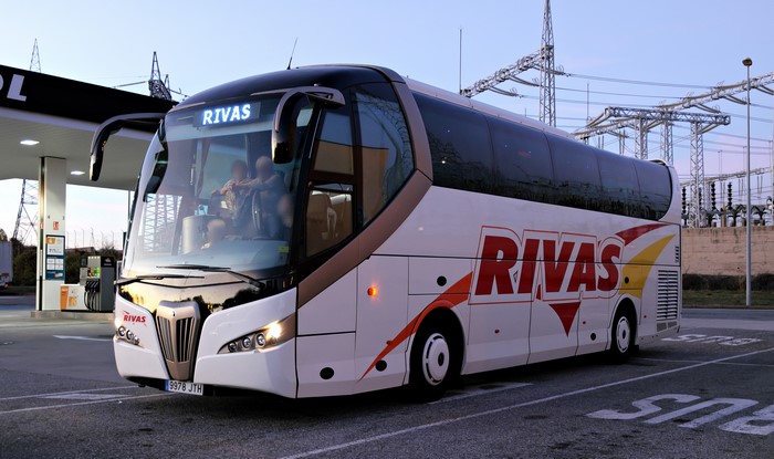 Rivas bus at a gas station with power lines in the background
