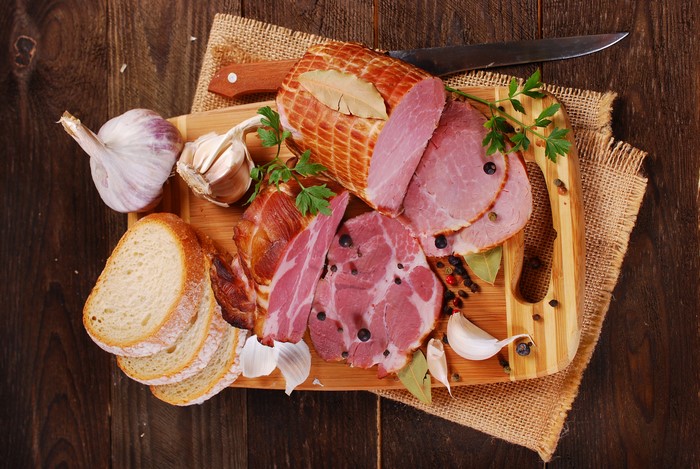 Ham, Bread, Garlic, and Knife on Cutting Board