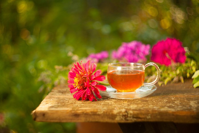 Tea and Zinnia flower on a wooden table