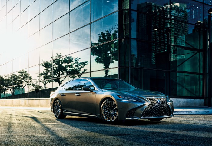 Lexus LS 500h parked in front of a modern glass building