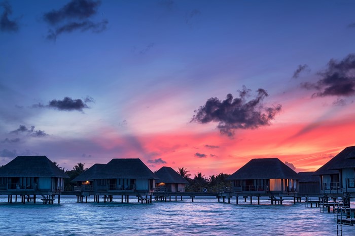 Overwater bungalows at sunset in the Maldives