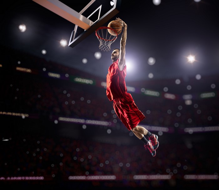 Basketball player in red uniform dunking