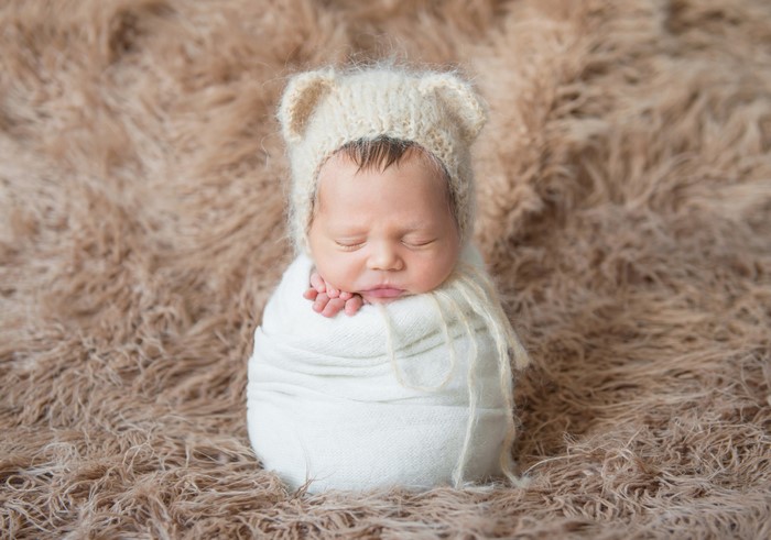 Newborn baby sleeping in a bear hat