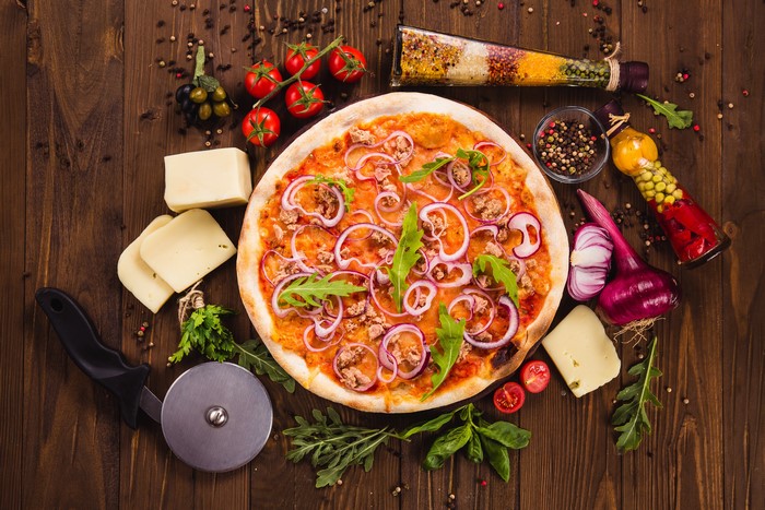 Pizza with Tuna, Onion, and Arugula on Wooden Table