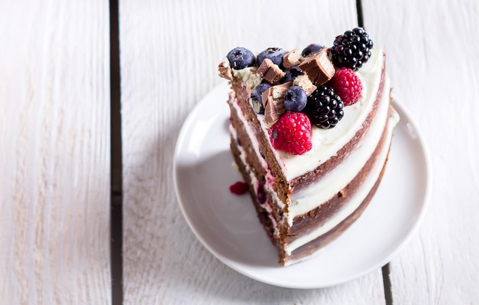 Slice of chocolate cake with berries and chocolate